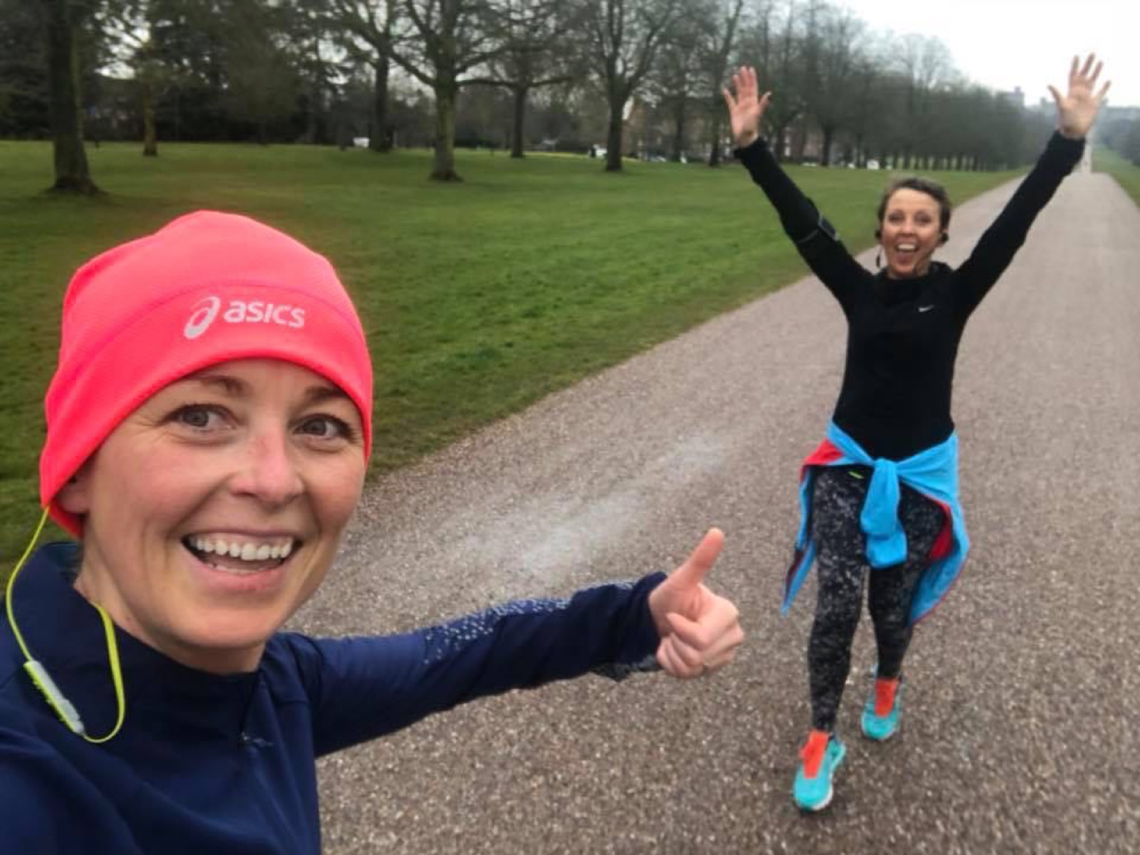 A winter run in the park: Cathy with her arms in the air, Tracey grinning in the foreground