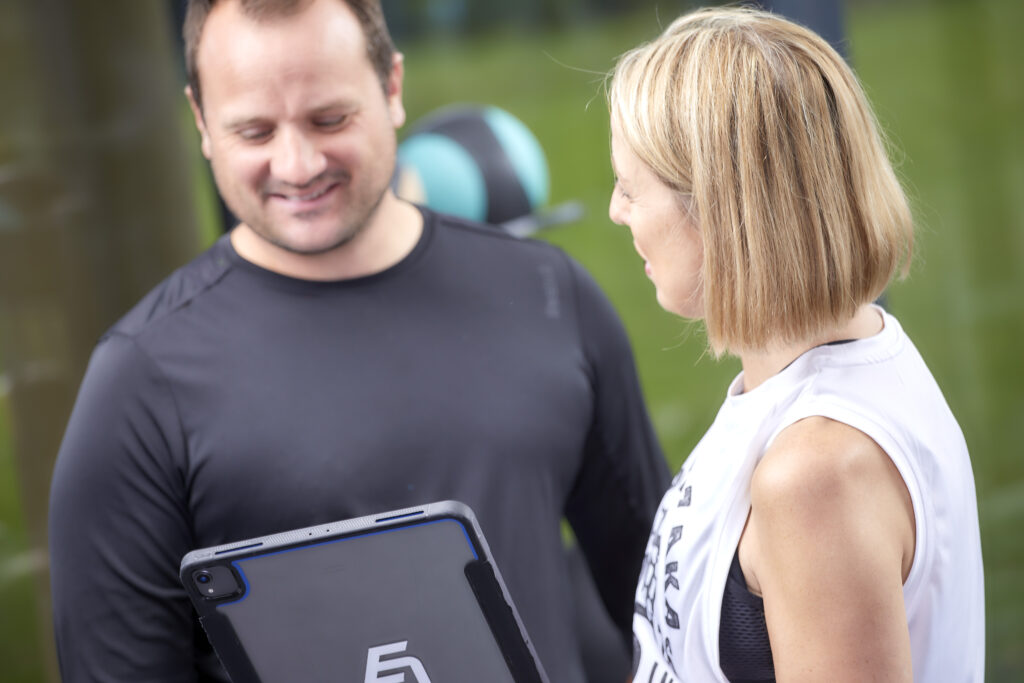 Tracey discussing a personalised exercise plan with a client for chronic health support.